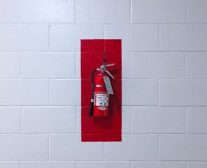 A fire extinguisher on a white wall.